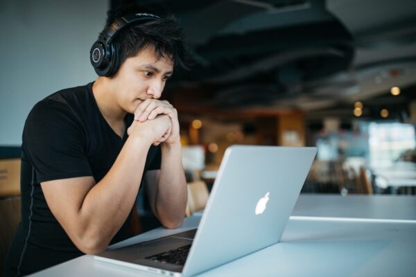 A man looking at his computer during a virtual therapy session